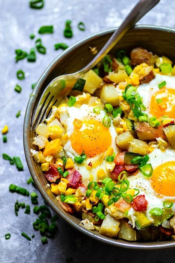A bowl of vegetable hash with fried eggs