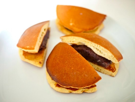 Two halved dorayaki sandwiches, showing their red bean fillings.