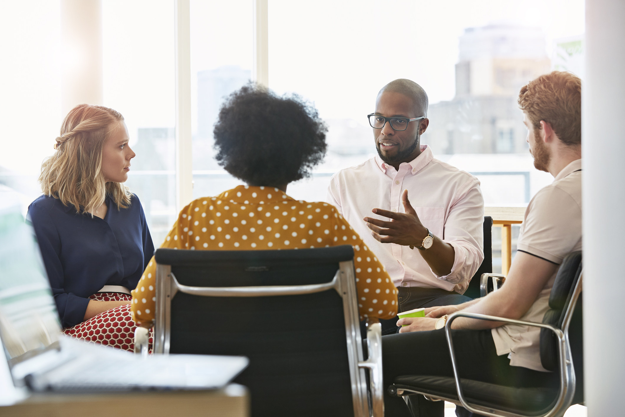 Four people having a conversation in an office