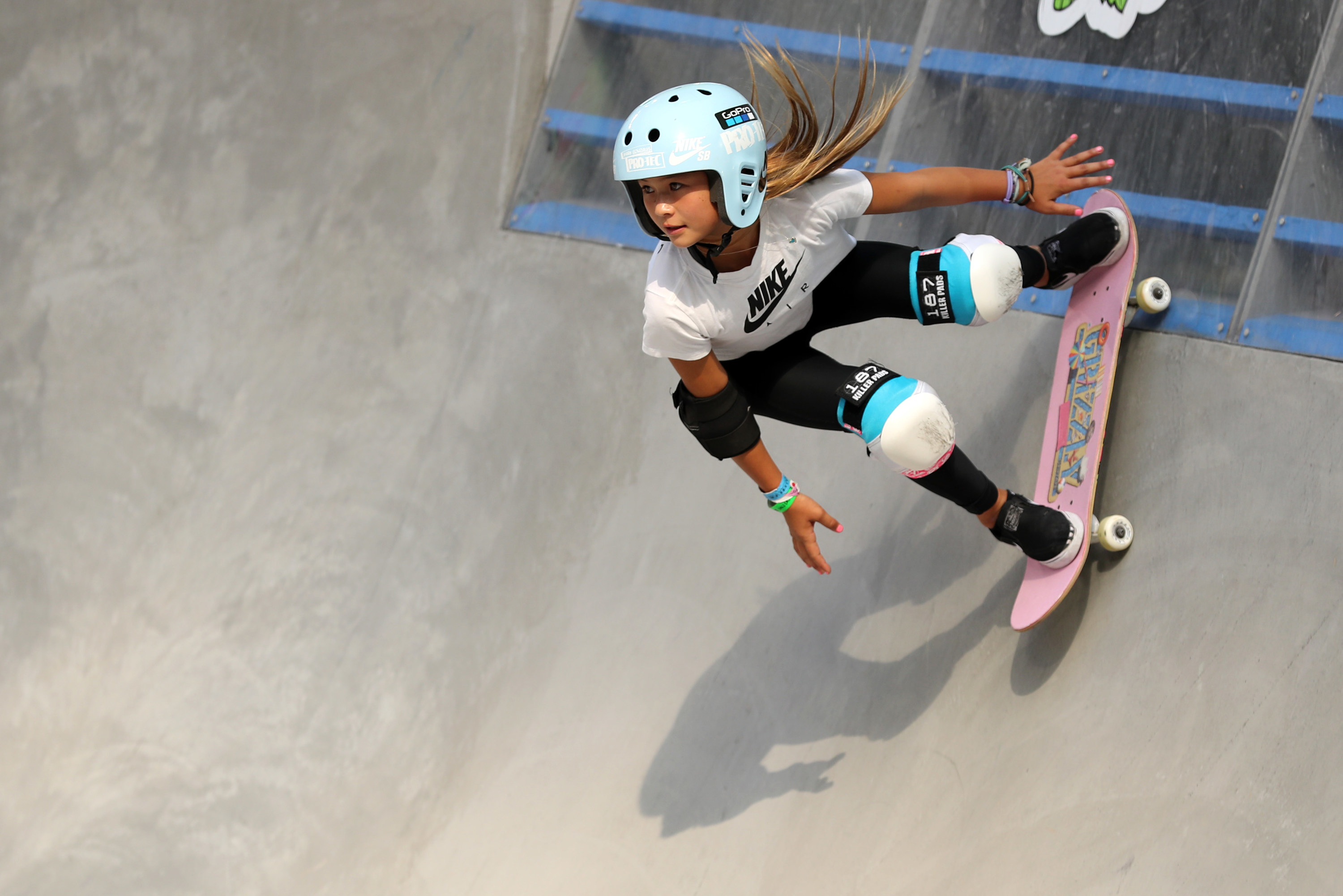 Sky Brown on a skateboard going down a skate park pool