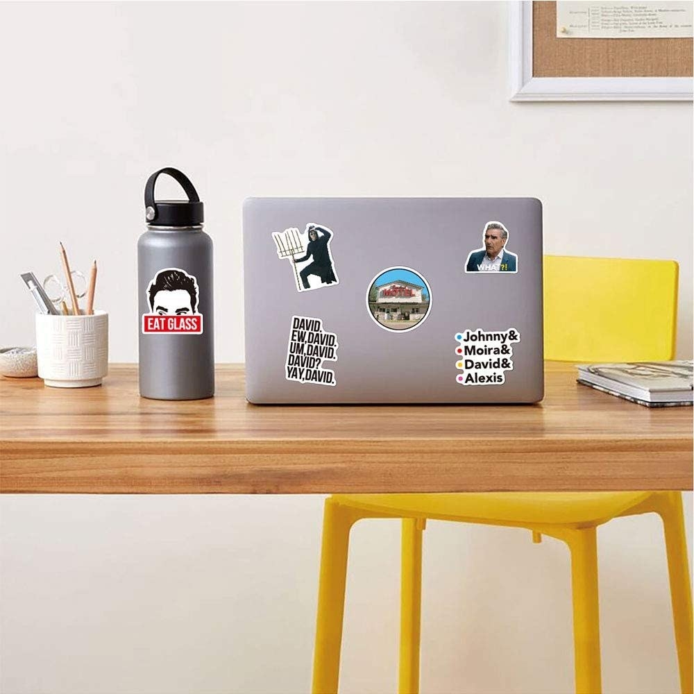 A laptop on a desk covered with stickers