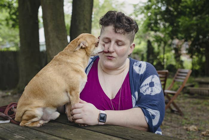 Prancer the Chihuahua licks the nose of his new mom, Ariel Davis, in a backyard seated setting