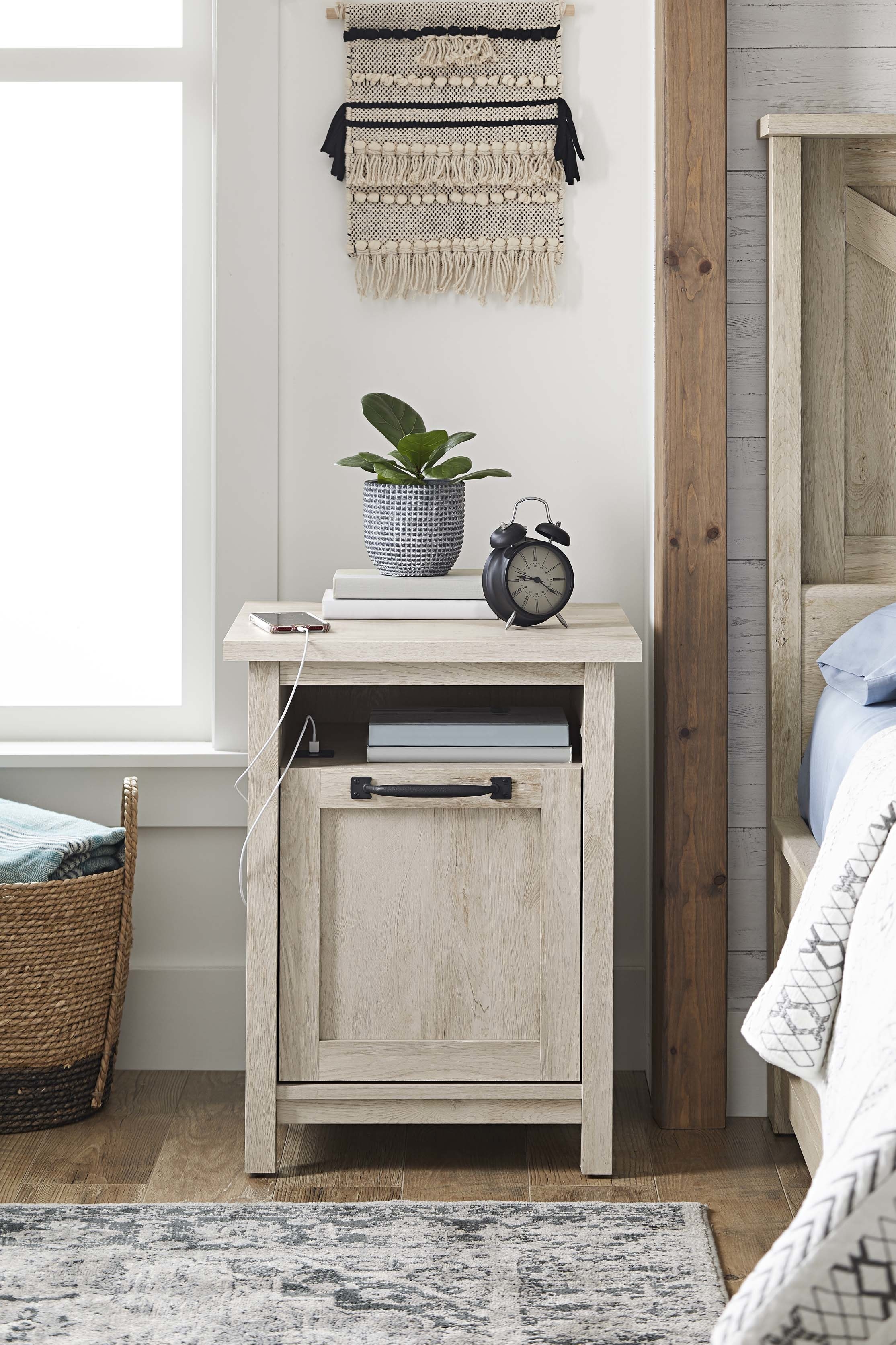 the white nightstand in a bedroom with a charging phone