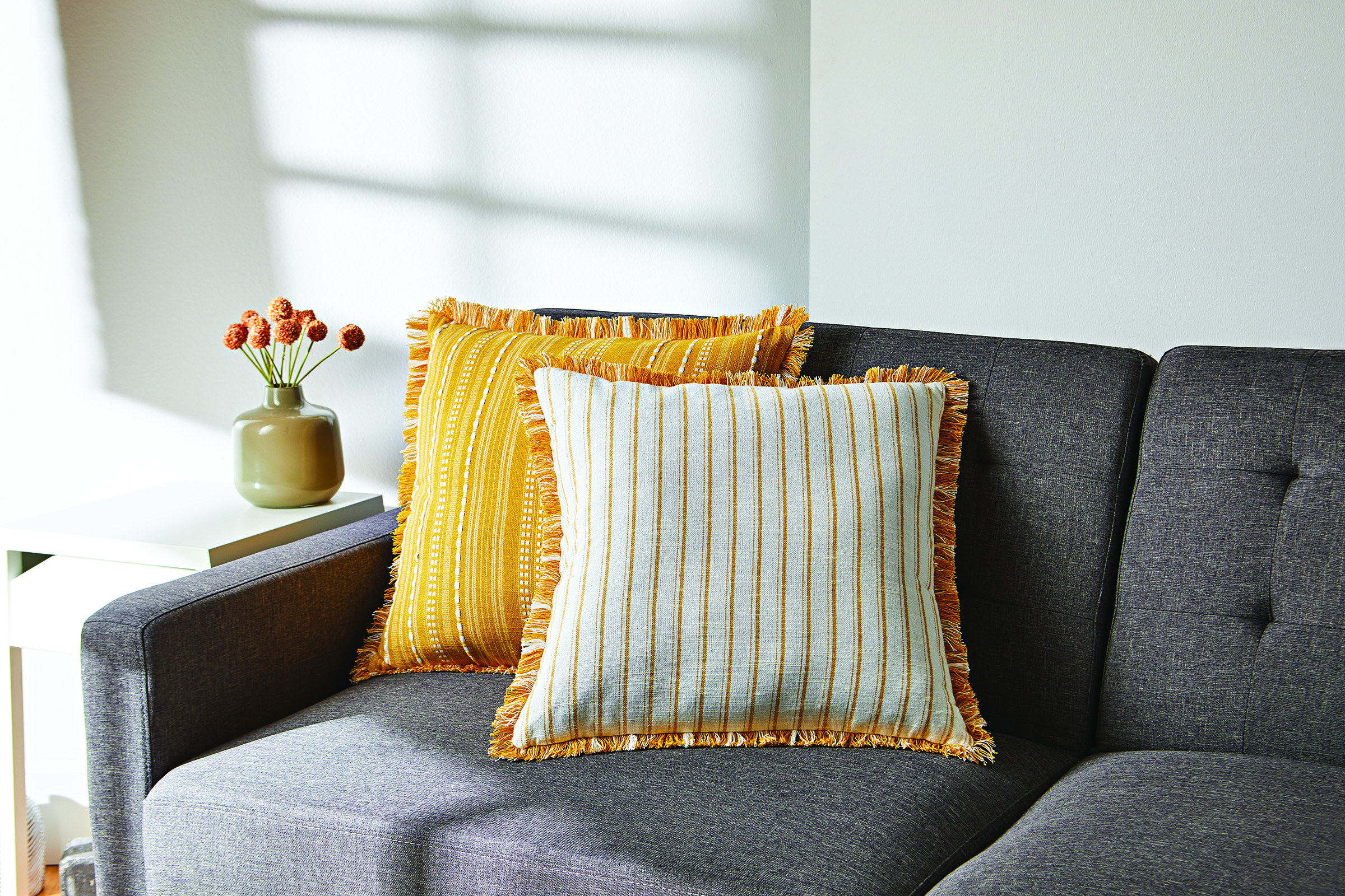 the yellow striped pillows on a couch