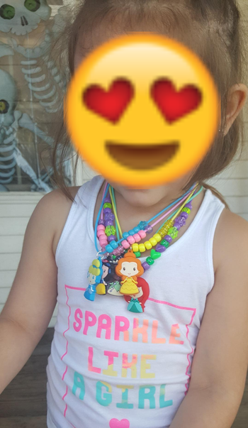 Reviewer's child showing wearing the necklaces they made