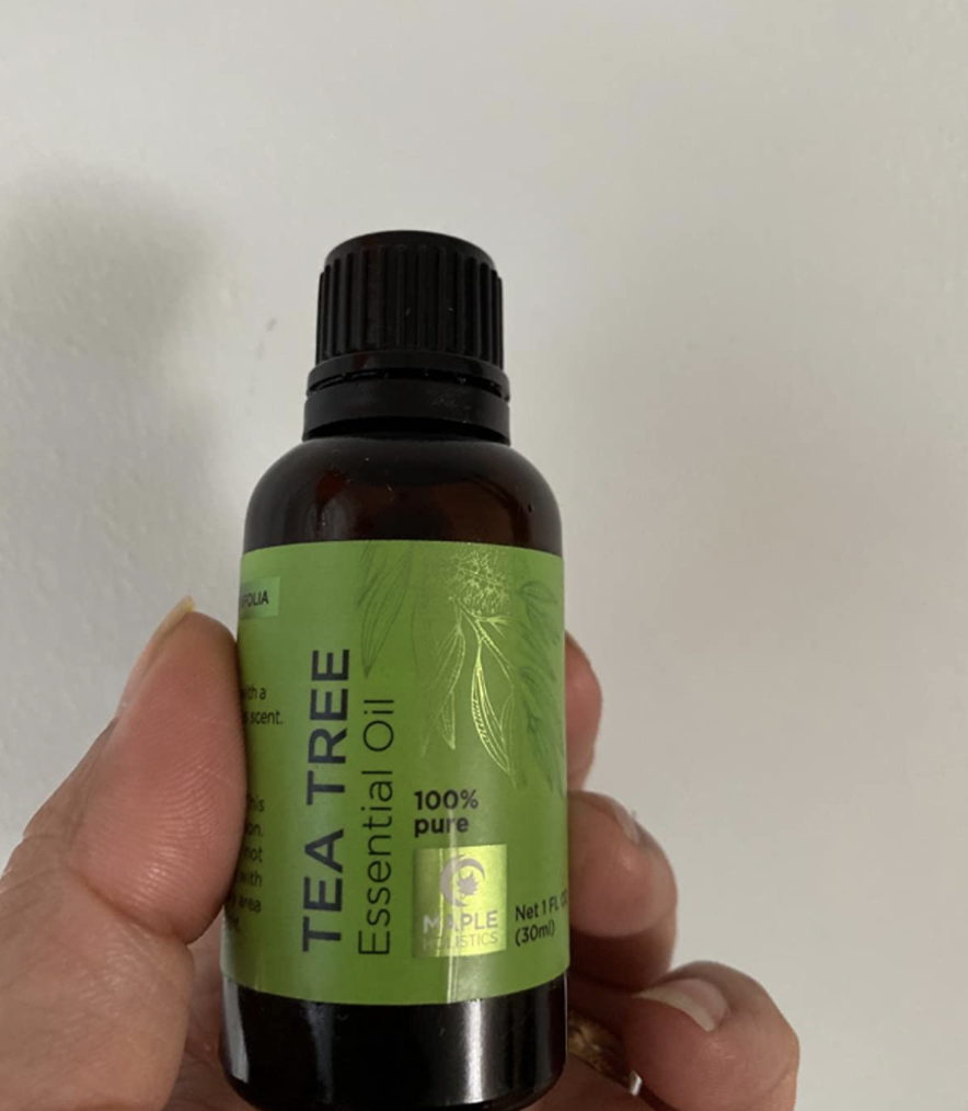A reviewer holding tea tree oil