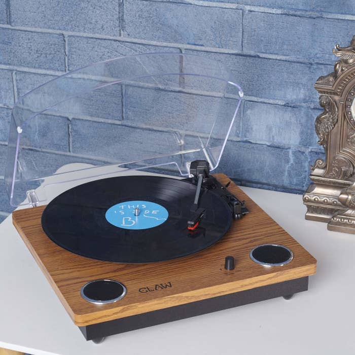 A modernised record player with a wooden finish and a transparent dust cover to protect your records from dust