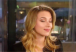 Scarlett Johansson raising her eyebrows and smiling mysteriously