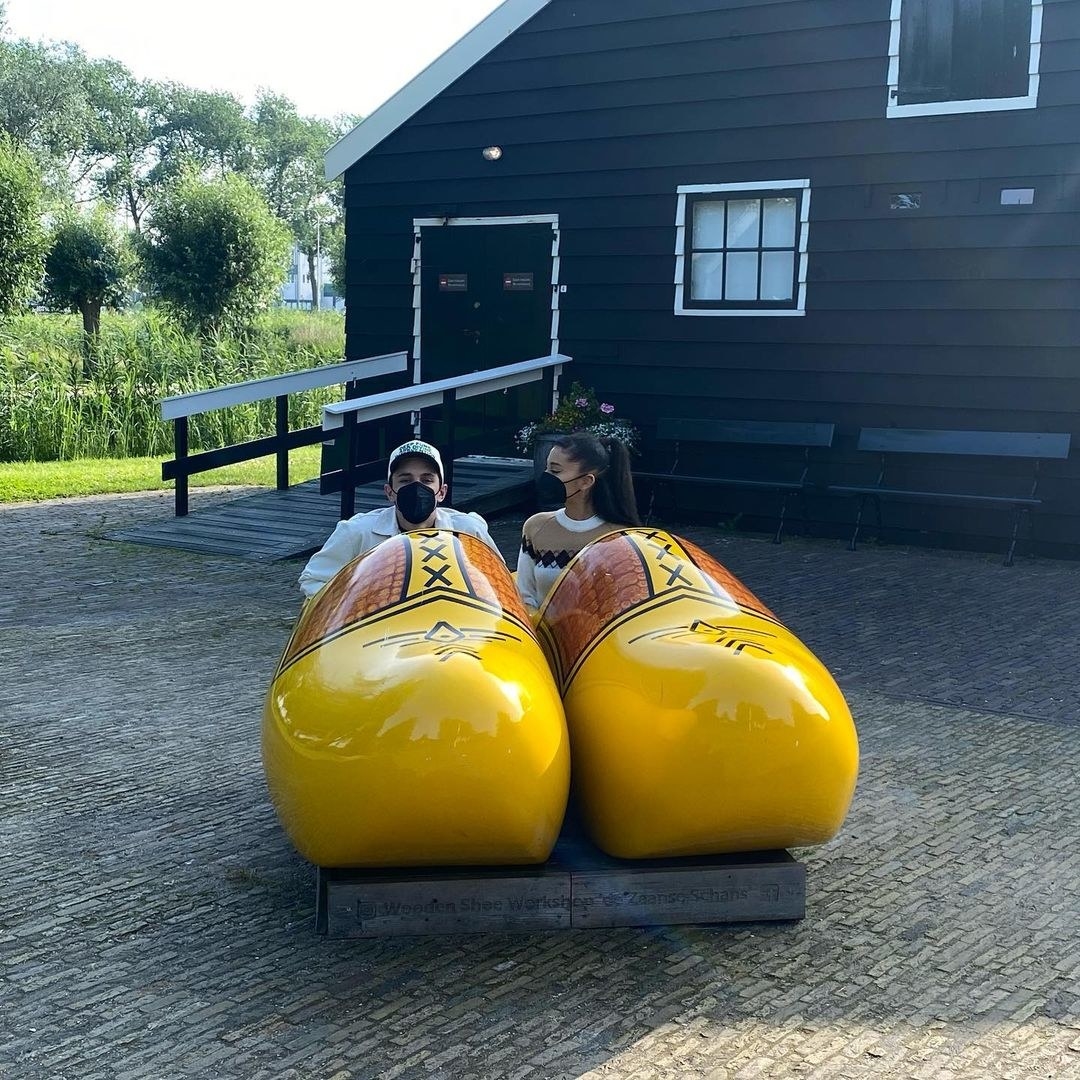 Ariana Grande and Dalton Gomez are photographed inside a pair of oversized wooden shoes