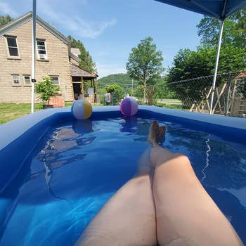 a reviewer photo of an adult lounging in the pool 