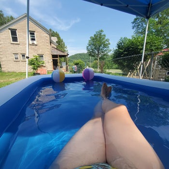 a reviewer photo of an adult lounging in the pool 