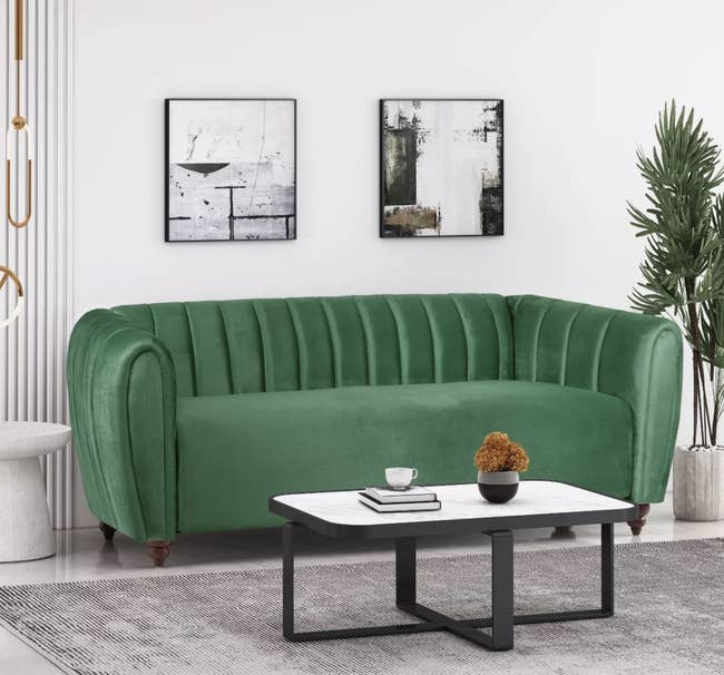 a green velvet sofa in a living room