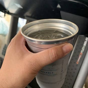 a reviewer photo of a hand holding a cup filled with an iced beverage 