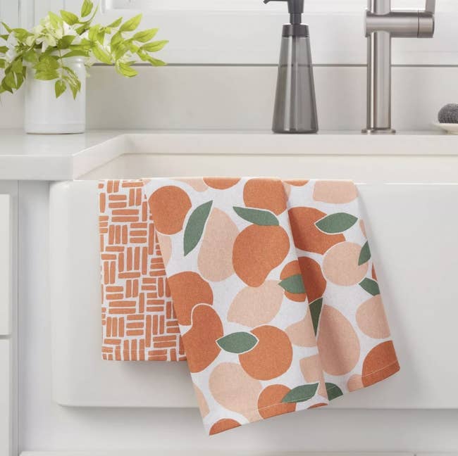 a kitchen towel set with oranges and abstract designs on them