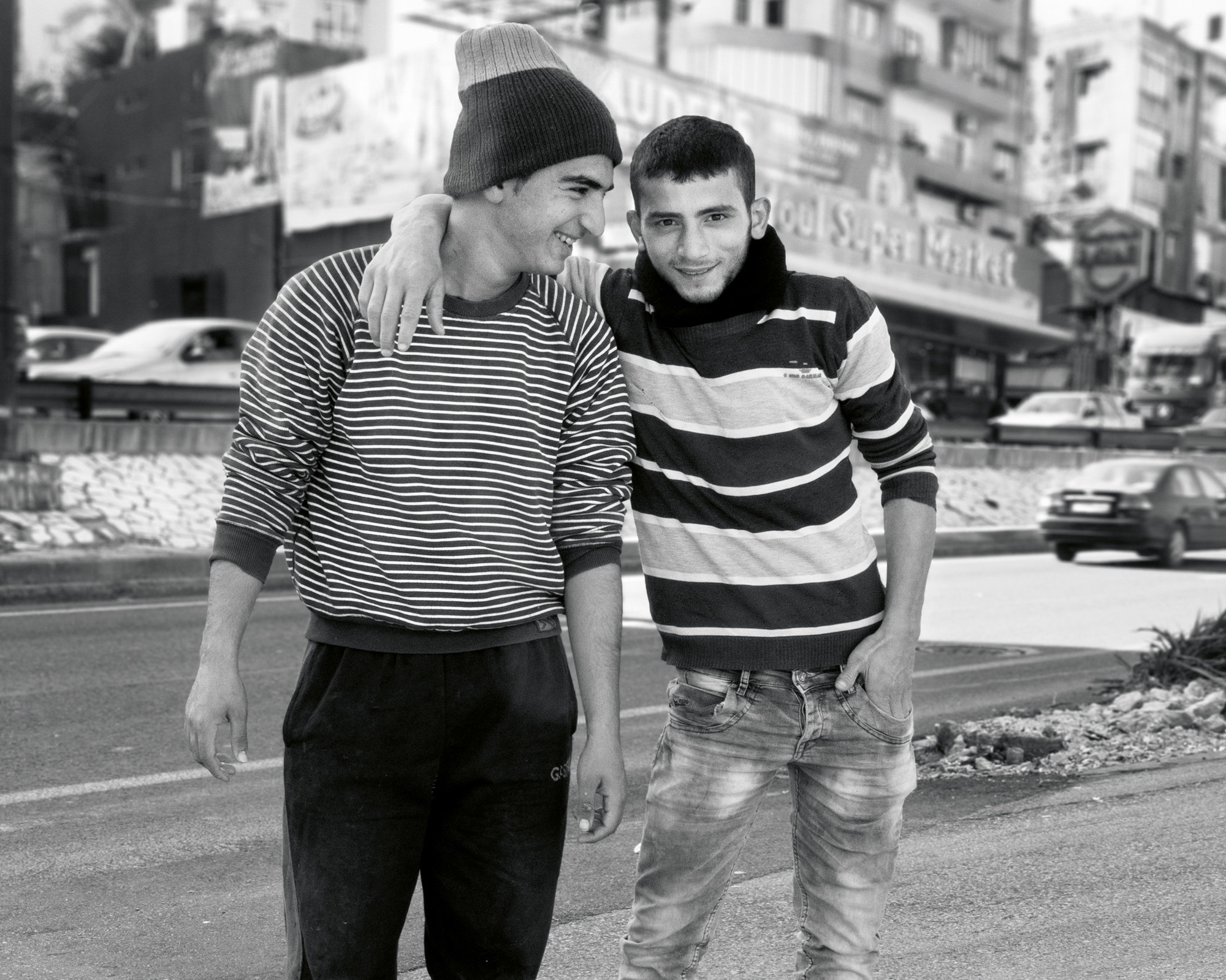 Two young men smile at each other and the photographer in Beirut