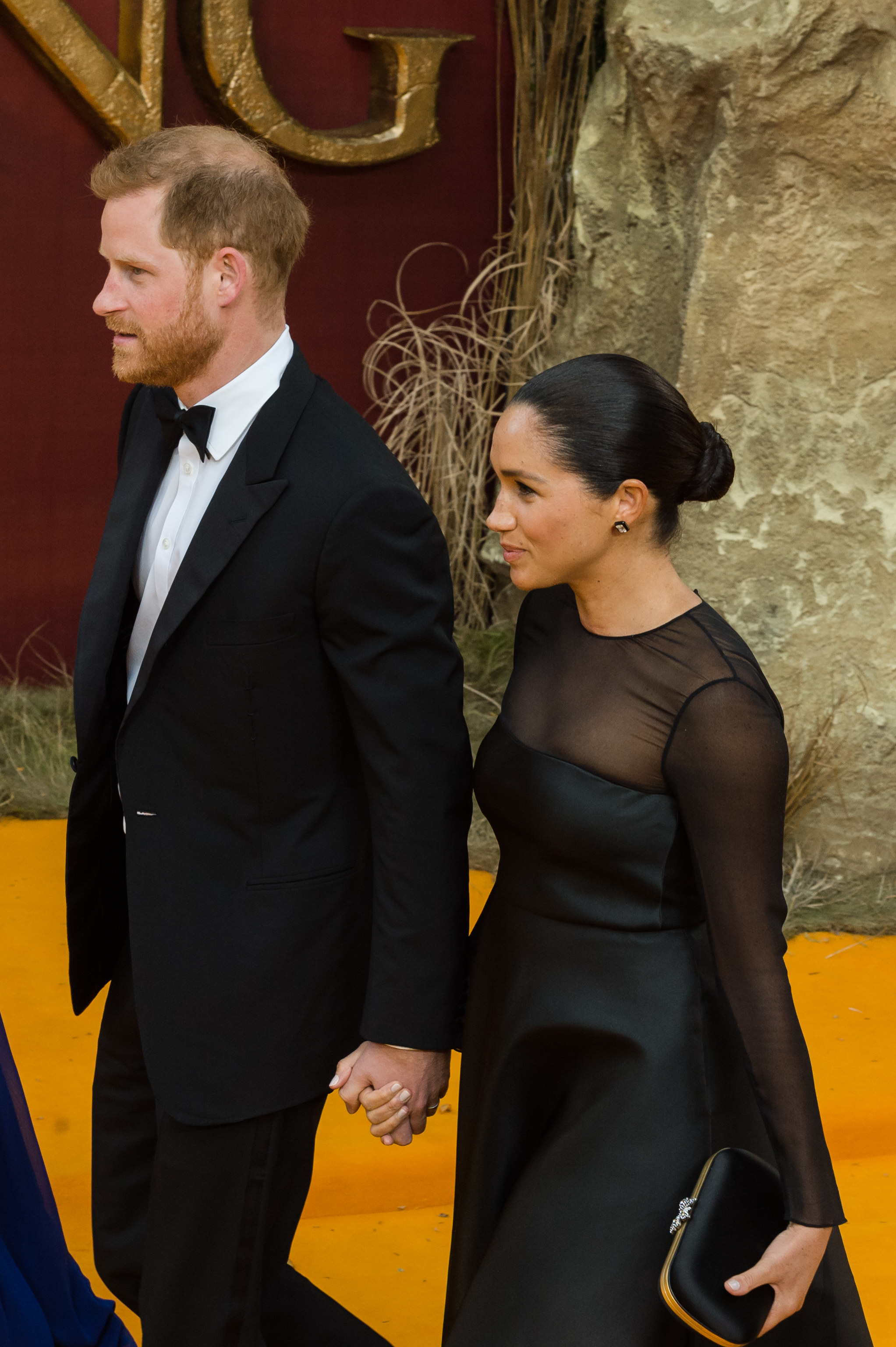 Prince Harry and Meghan walking hand in hand at an event