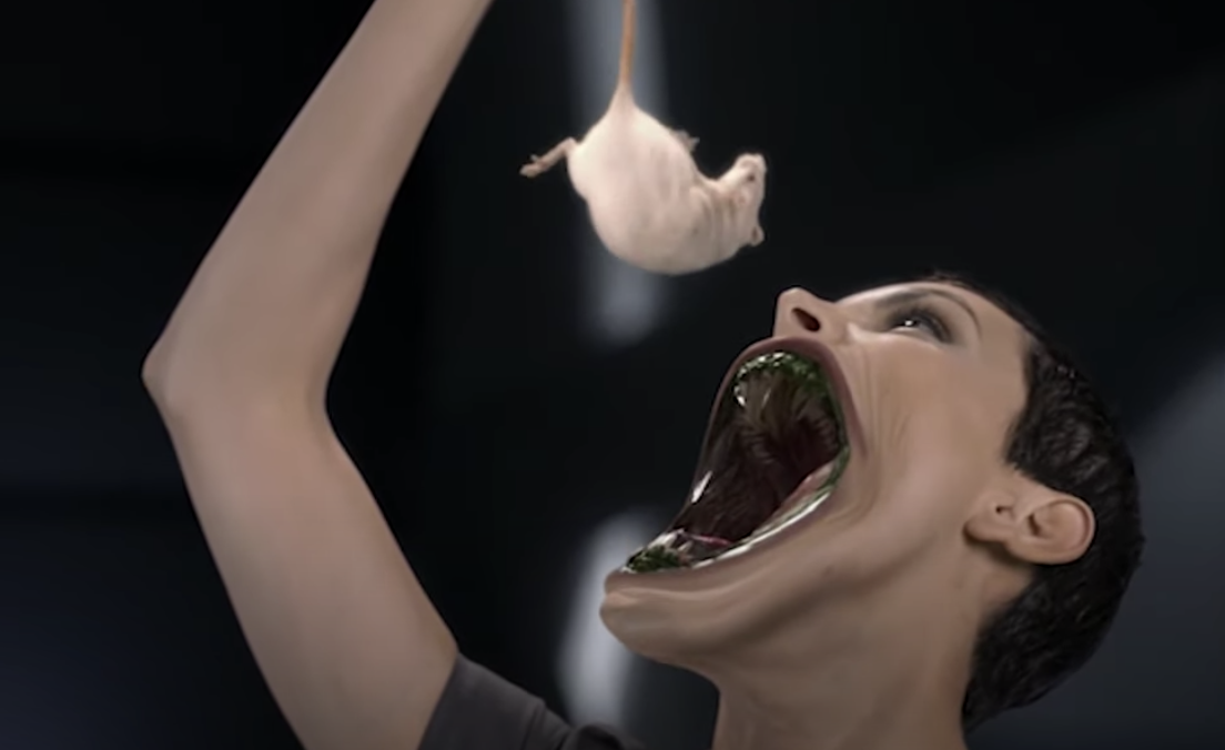 woman unhinging her jaw to eat a mouse