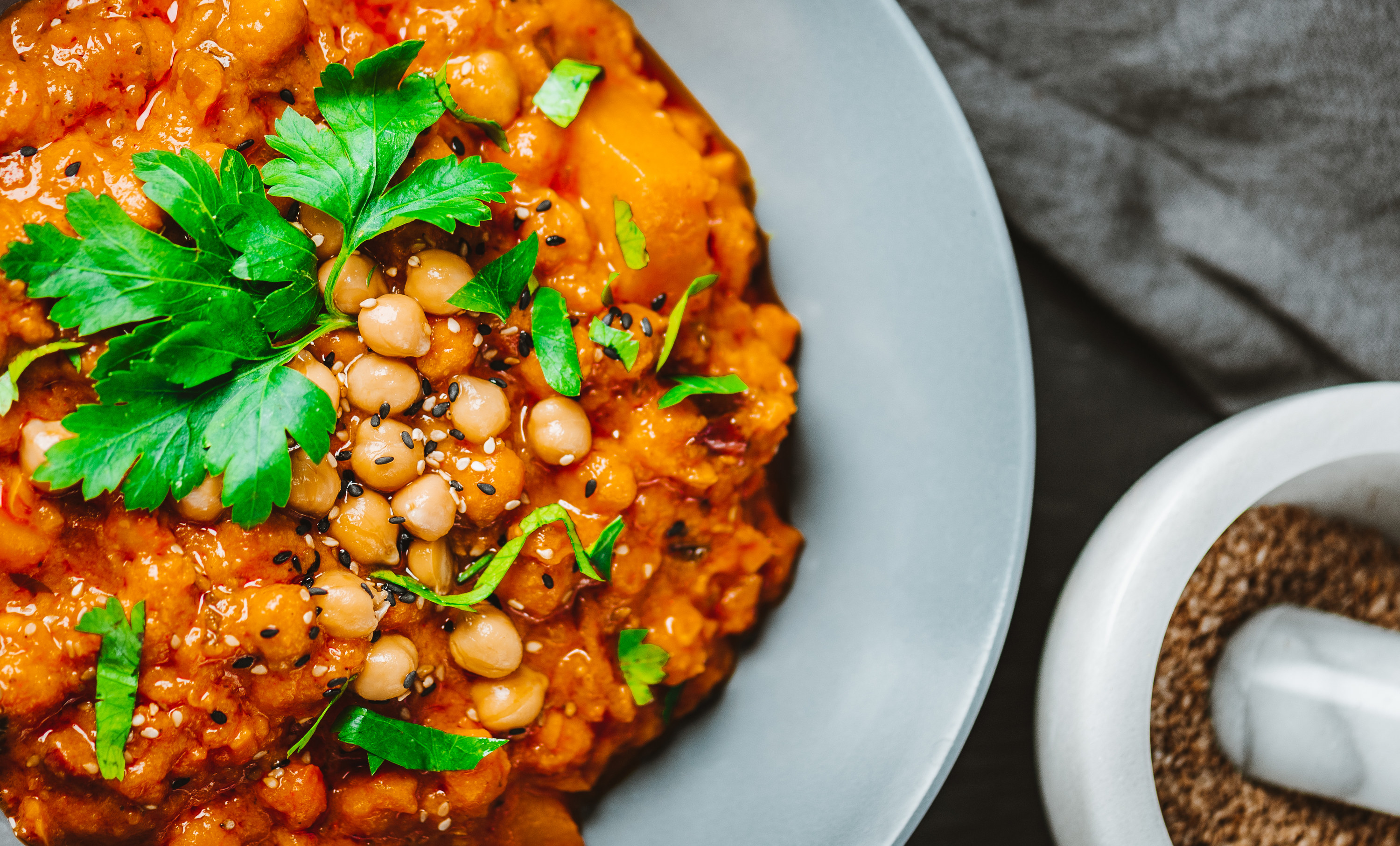 Chana masala is topped with cilantro and served in a white bowl