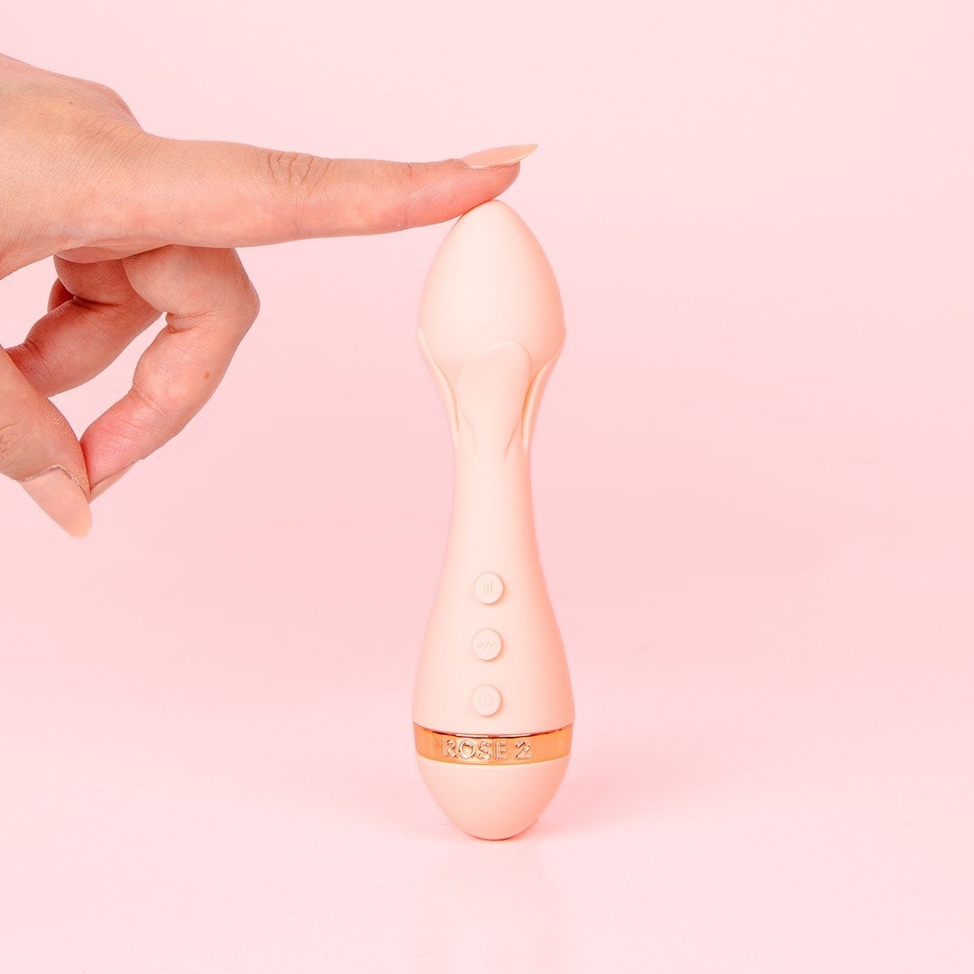 Model touching top of light pink bullet vibrator