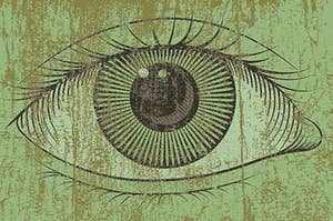 an eye on a green wooden board 