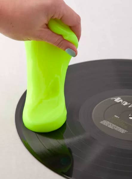 A person using the cleaning goo to clean a record