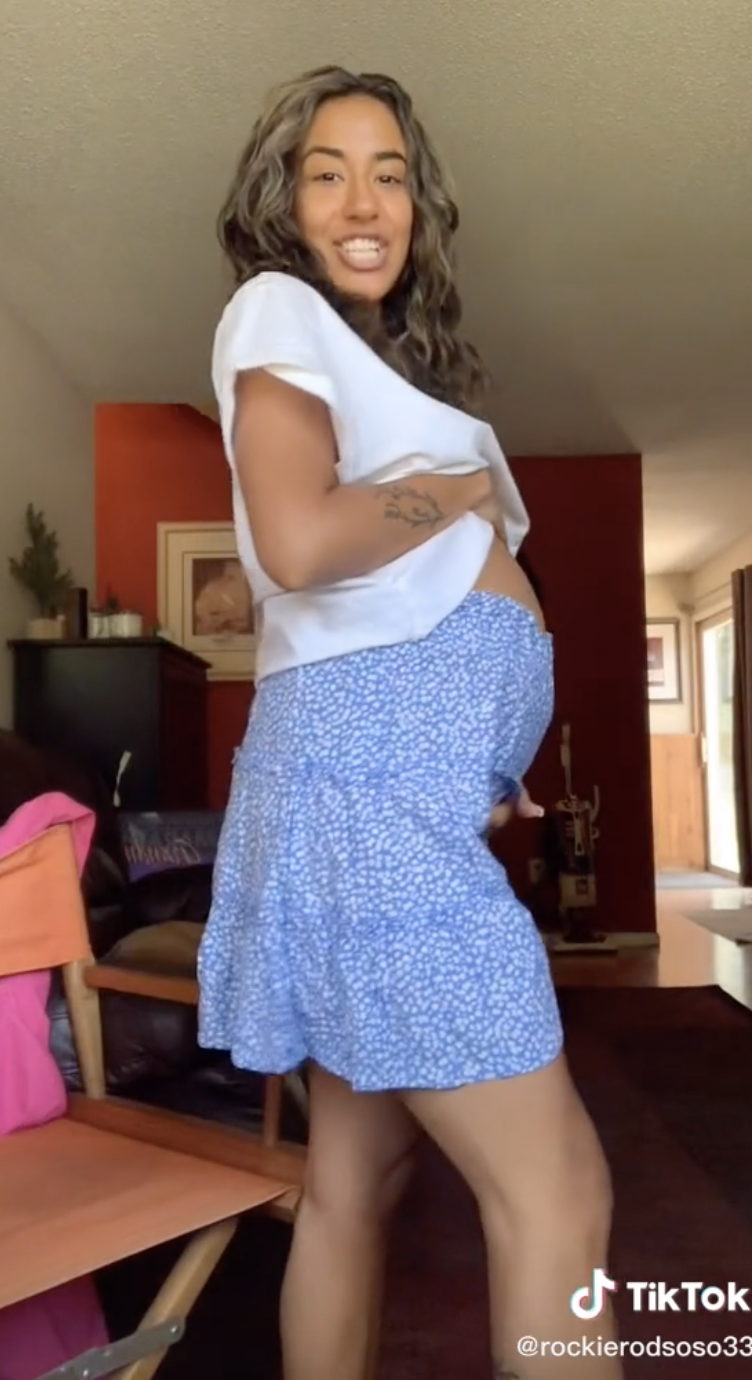 A screenshot pulled from the TikTok about the ovarian cyst with the woman standing to the side showing her protruding stomach