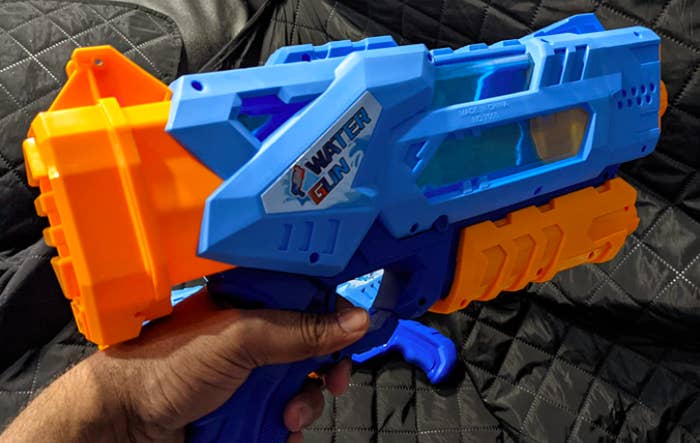 reviewer&#x27;s hand holding the water gun