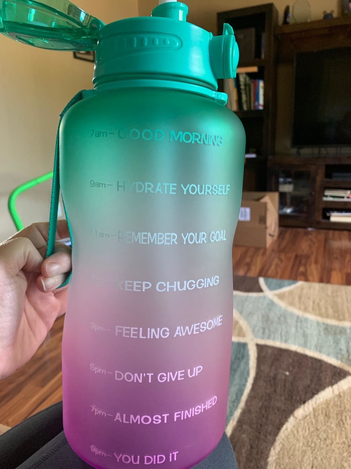 The bottle in pink and green with time stamps and motivational phrases like &quot;keep chugging,&quot; &quot;feeling awesome,&quot; and &quot;don&#x27;t give up&quot;