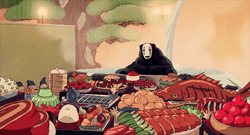 Kaonashi from Spirited Away cheers as he is seated in front of a feast