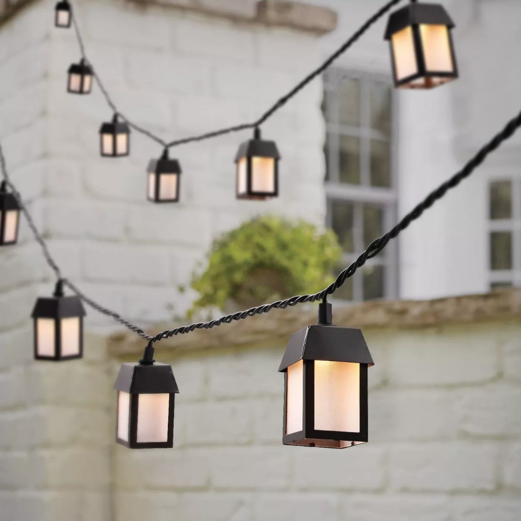 black, metal lantern string lights hanging outdoors