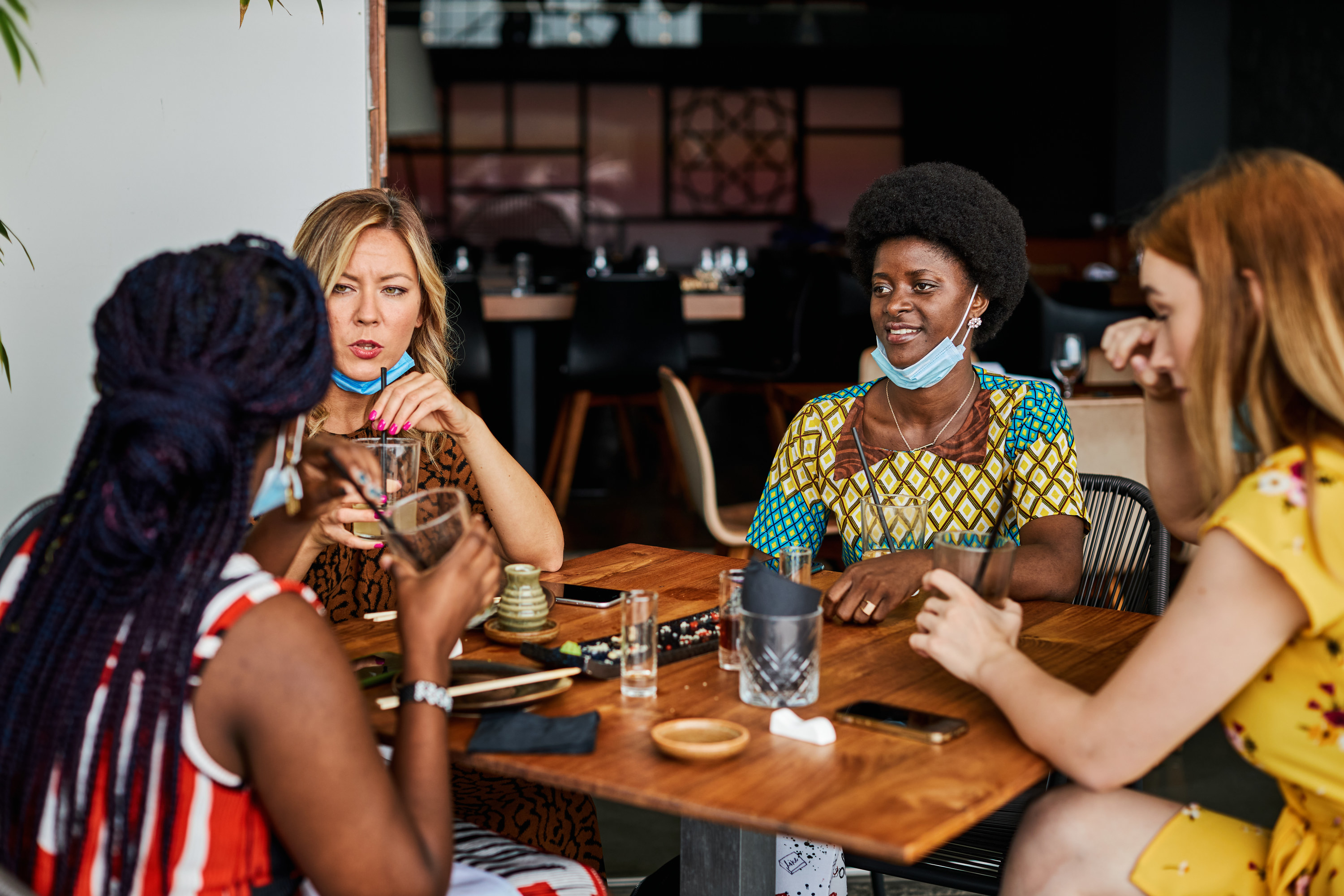 Group of millennial women sitting at a restaurant table