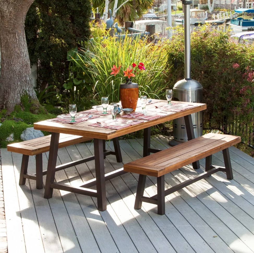 A brown, rustic picnic table style dining set with two bench on a patio