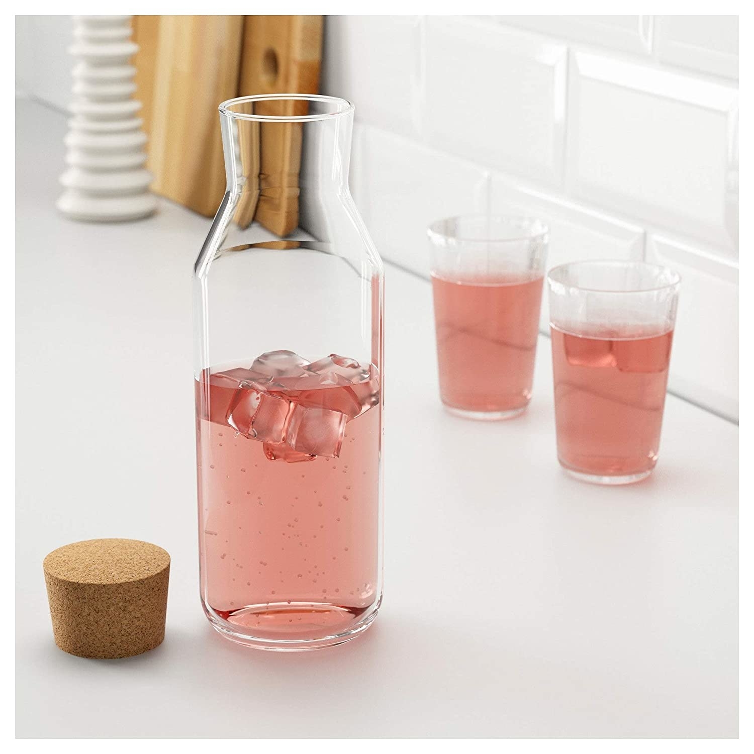 A glass pitcher with a pink beverage in it