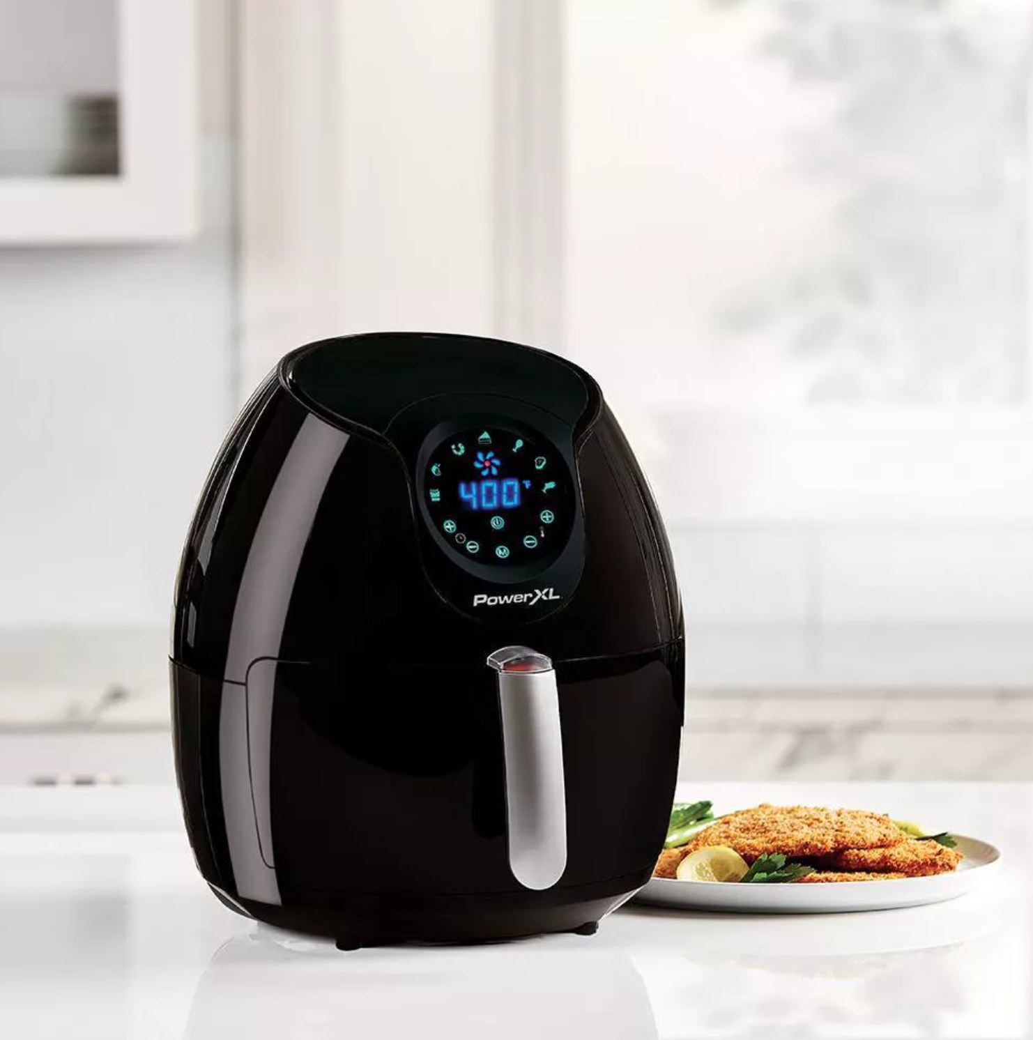 the black air fryer next to a plate of food