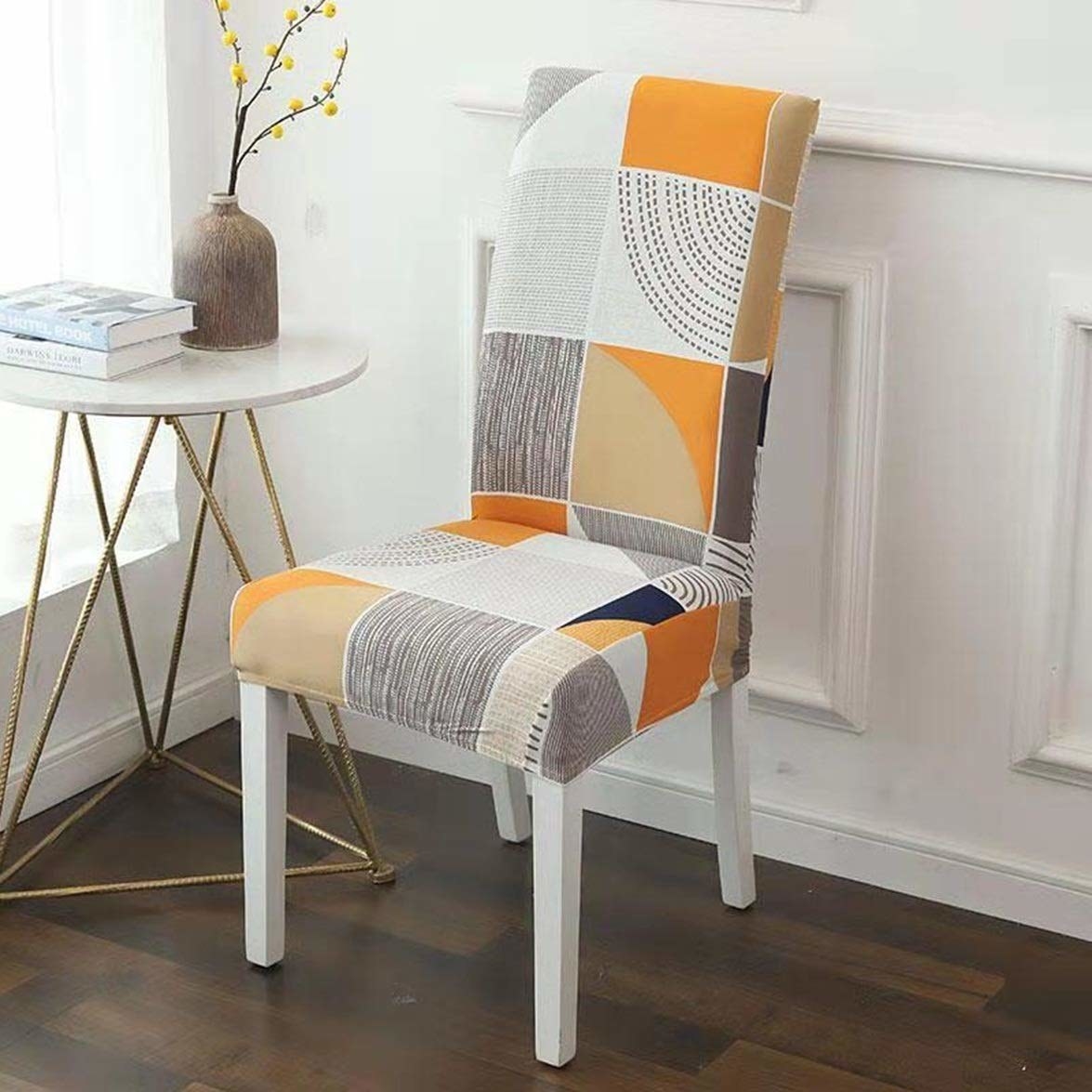 A chair covered with an orange and black slip cover with big checkers and an abstract design
