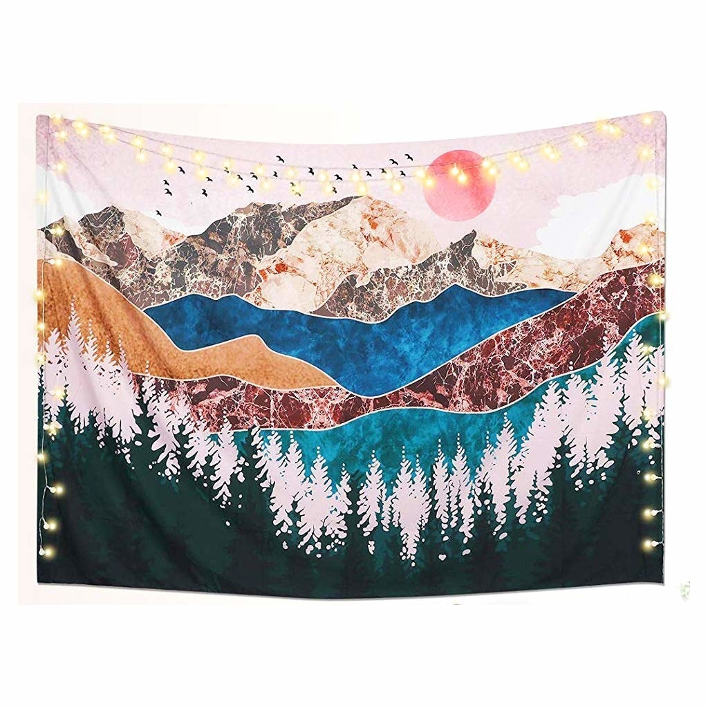 A tapestry with pine trees, layers of mountains and the sun in the back