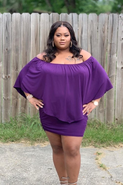 Reviewer wearing purple dress with the sleeves set as an off the shoulder dress