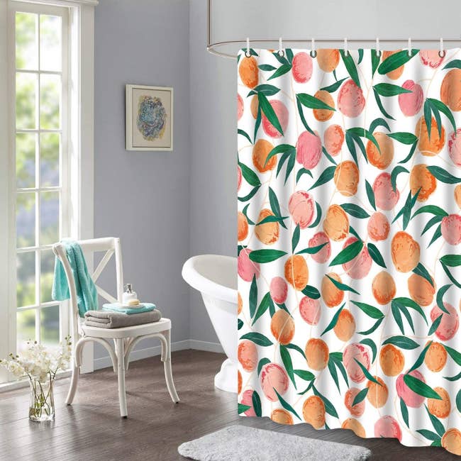The peach print shower curtain lining a large bathtub