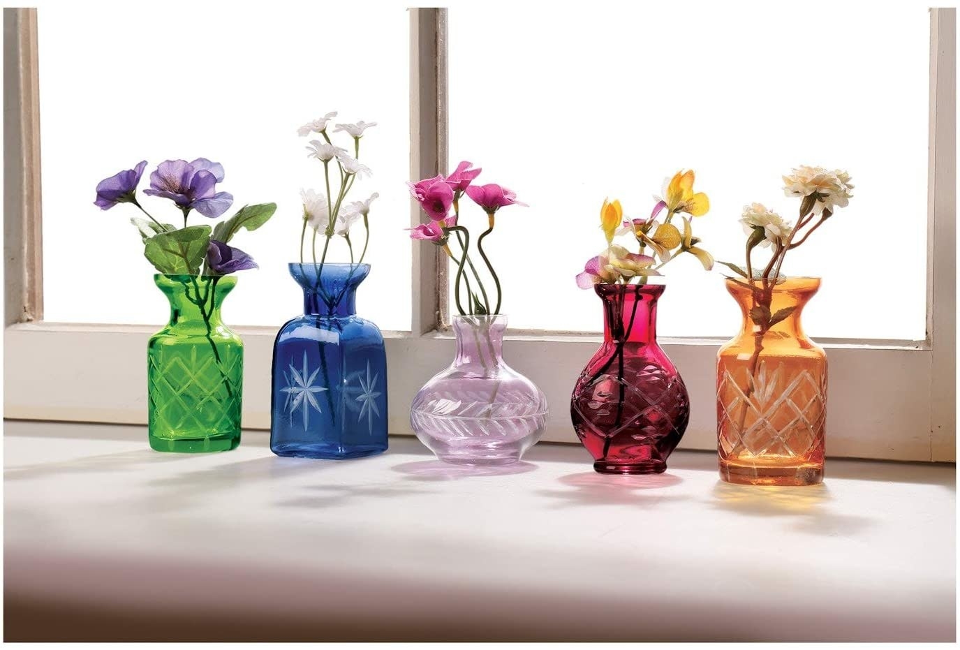 The set of colorful vases up against a window
