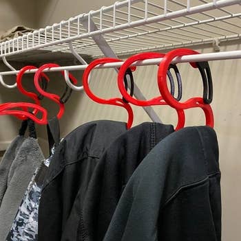 several hoodies on the hangers in a closet 