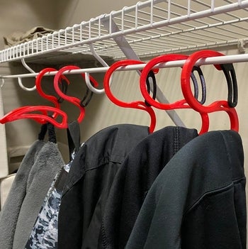 several hoodies on the hangers in a closet 