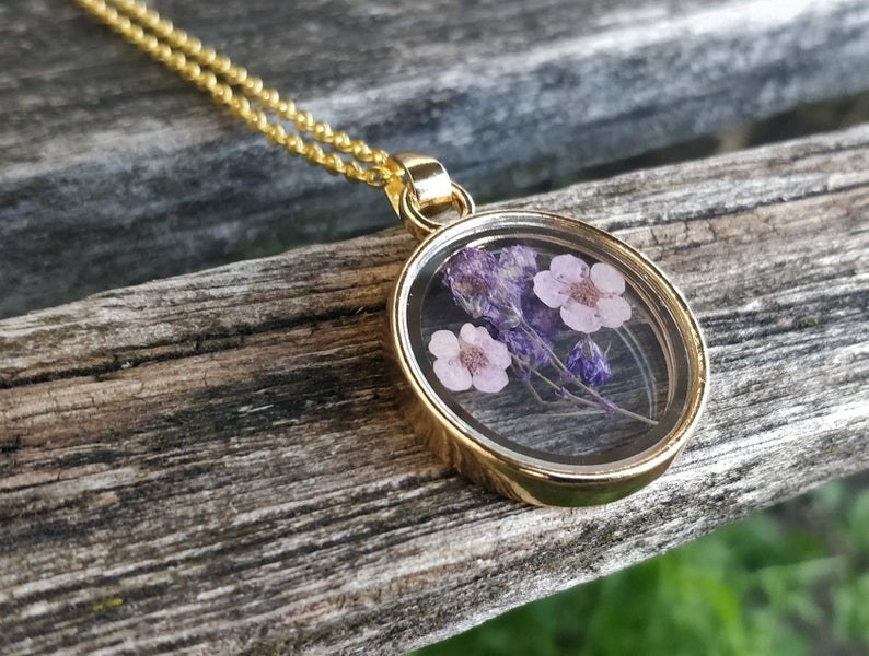 The gold necklace with a pressed flower pendant