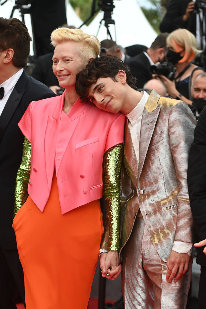 Tom holding hands with Tilda and resting his head on her shoulder