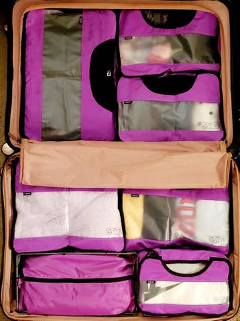 a reviewer's bag packed neatly with purple packing cubes