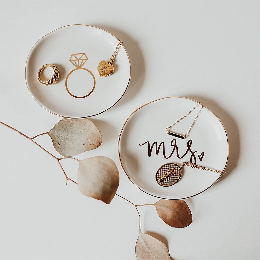 Two different variants of the ceramic dish with a gold ring and the words &#x27;Mrs&#x27; printed one each respectively.