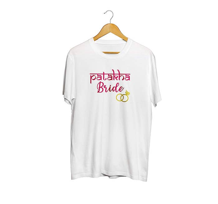 A white tee with the words 'Patakha Bride' printed on it in pink along with a golden engagement ring