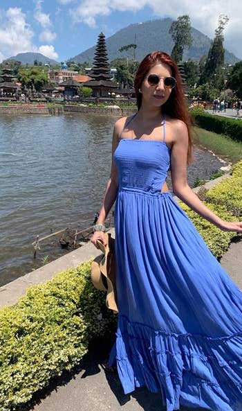 model wearing the blue maxi dress with cut outs and ruffle tier detailing on the skirt