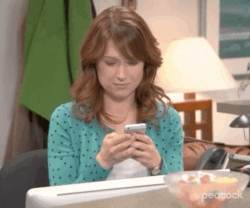 Erin from &quot;The Office&quot; smiling at her phone