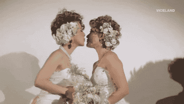 Two women kissing during a wedding photoshoot