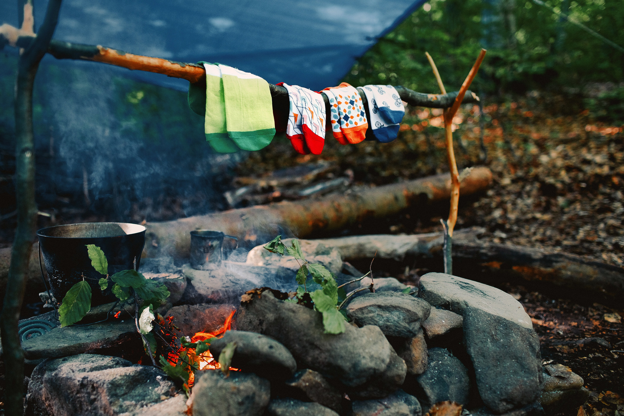 Four pairs of socks drying over a fire.